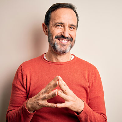 middle aged man smiling and tenting fingers